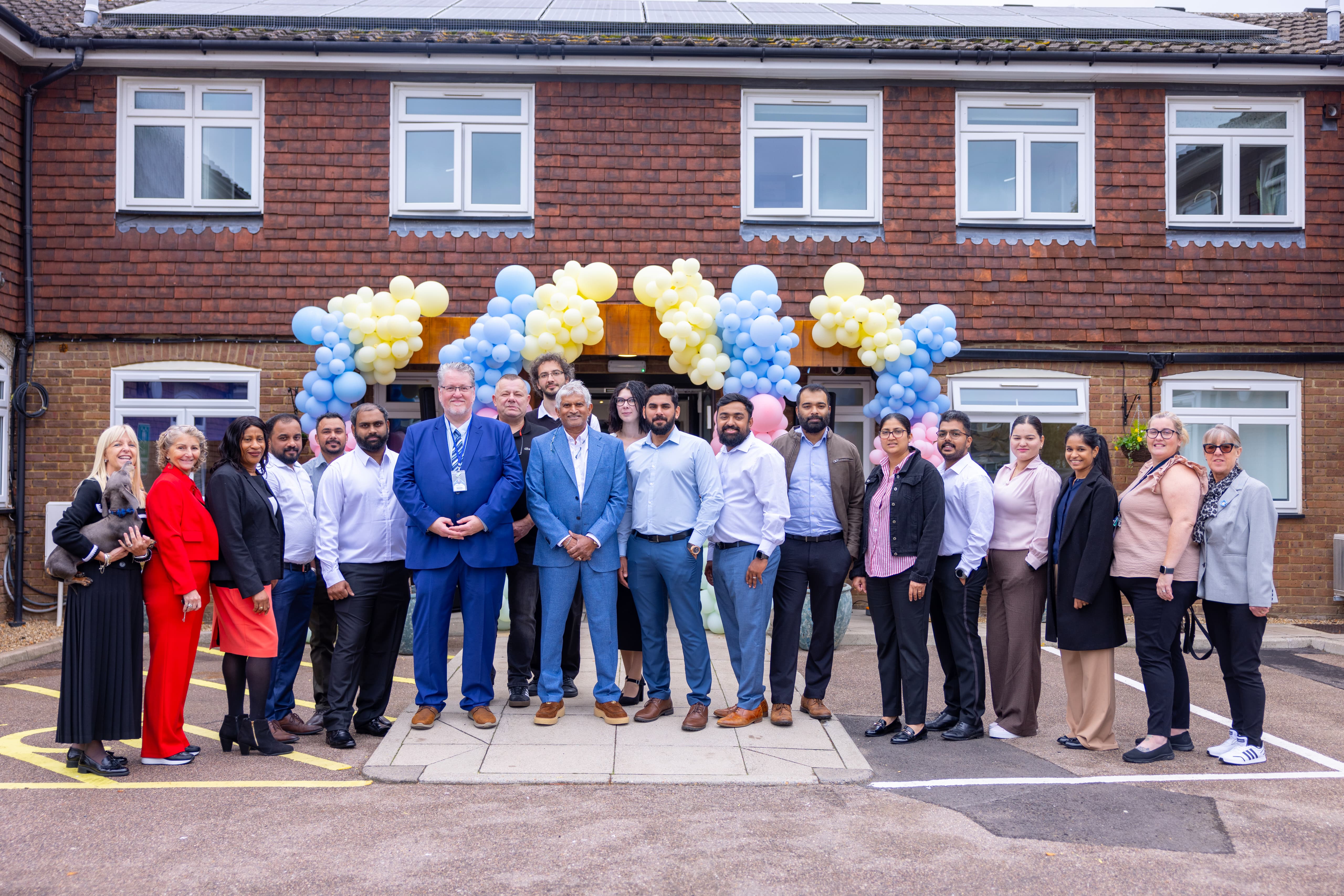 Lower Farm Nursing Home dedicated team standing together outside the facility with celebratory balloons
